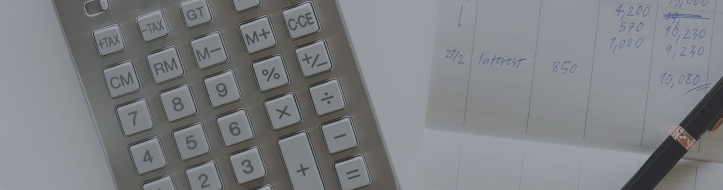 Closeup image of calculator, notepad, and pen.